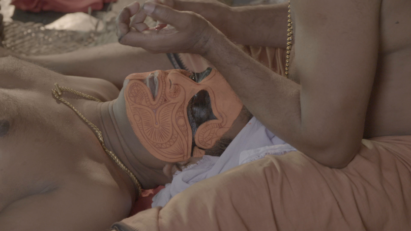 Theyyam artist applying Makeup