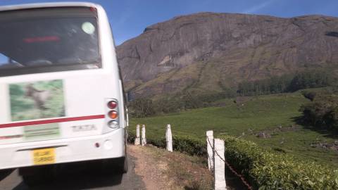 Tourist bus along a hillside road in Kerala