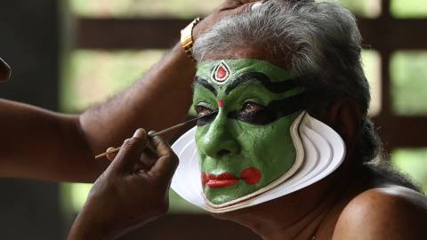 Kathakali artist applying makeup