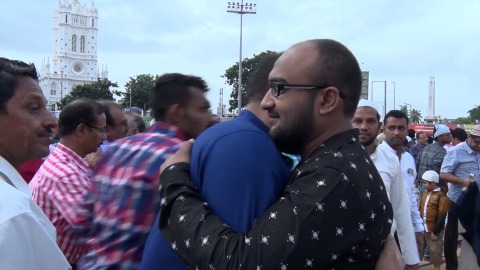 Muslims embrace each other after prayers