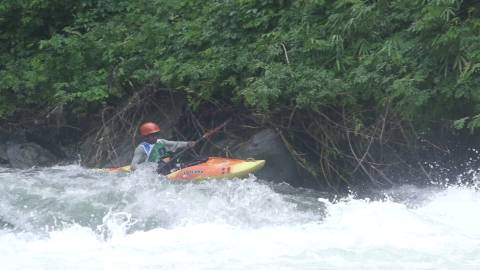 Participant kayaking down a river in rain