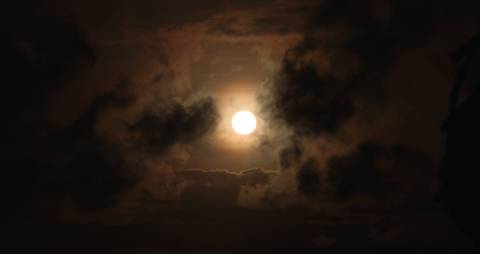 Brightly lit moon on a cloudy sky
