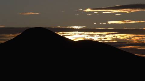 Sunrise above silhouette of a mountain range
