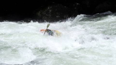 Slow-motion shot of athlete kayaking down a river