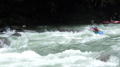 Kayaking athlete navigating down a river